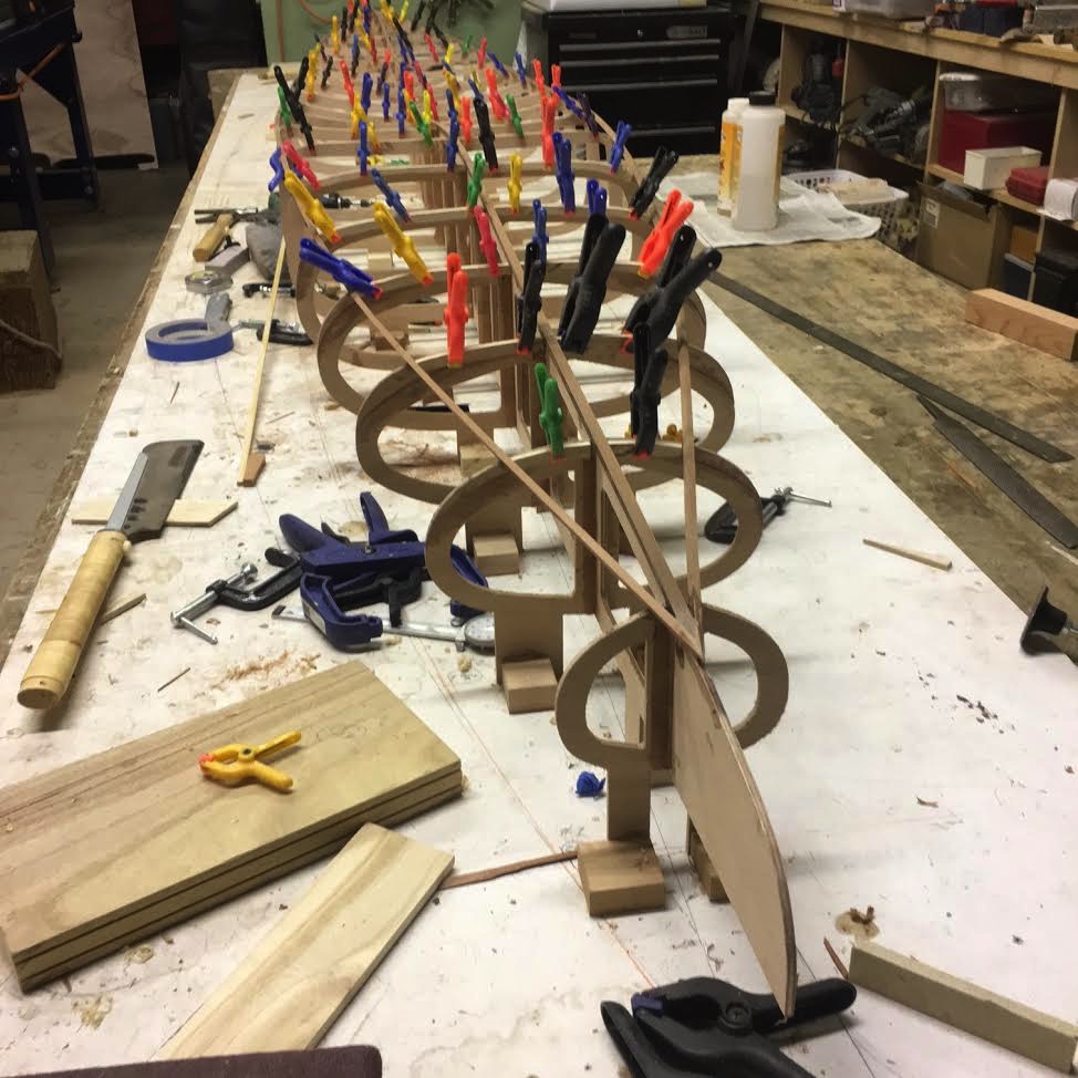 paddleboard under construction with clamps holding frame together